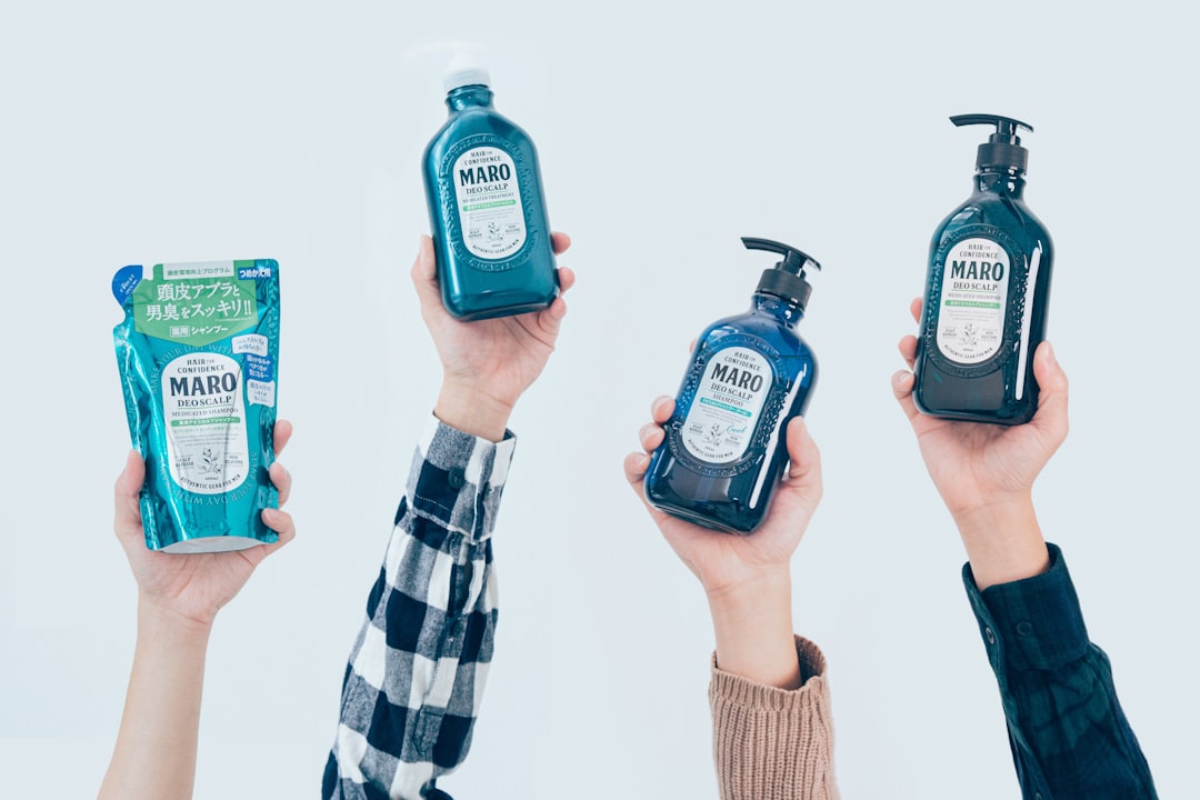 a group of hands holding bottles of alcohol