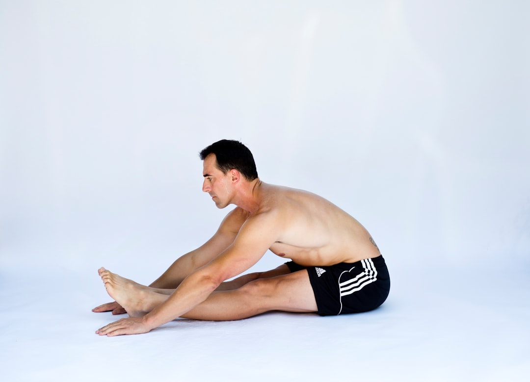 a shirtless man is sitting on the floor