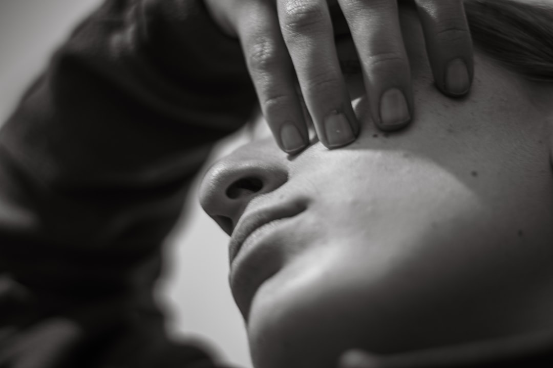 Close-up of a person's face with hand covering eye