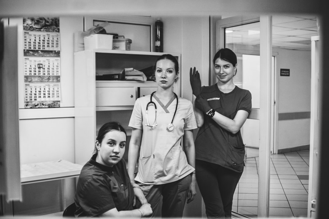 Three medical professionals posing in a hospital hallway.