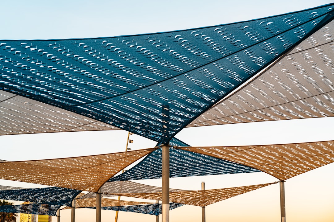 Triangular shade sails creating geometric patterns