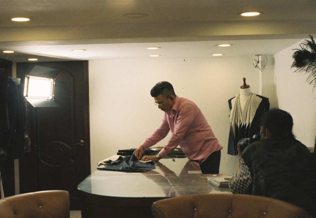 a man ironing clothes on a table in a room