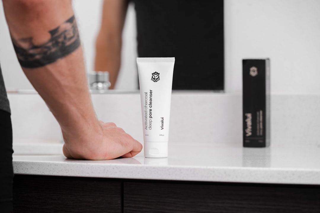 a person standing next to a counter with a tube of cream on it