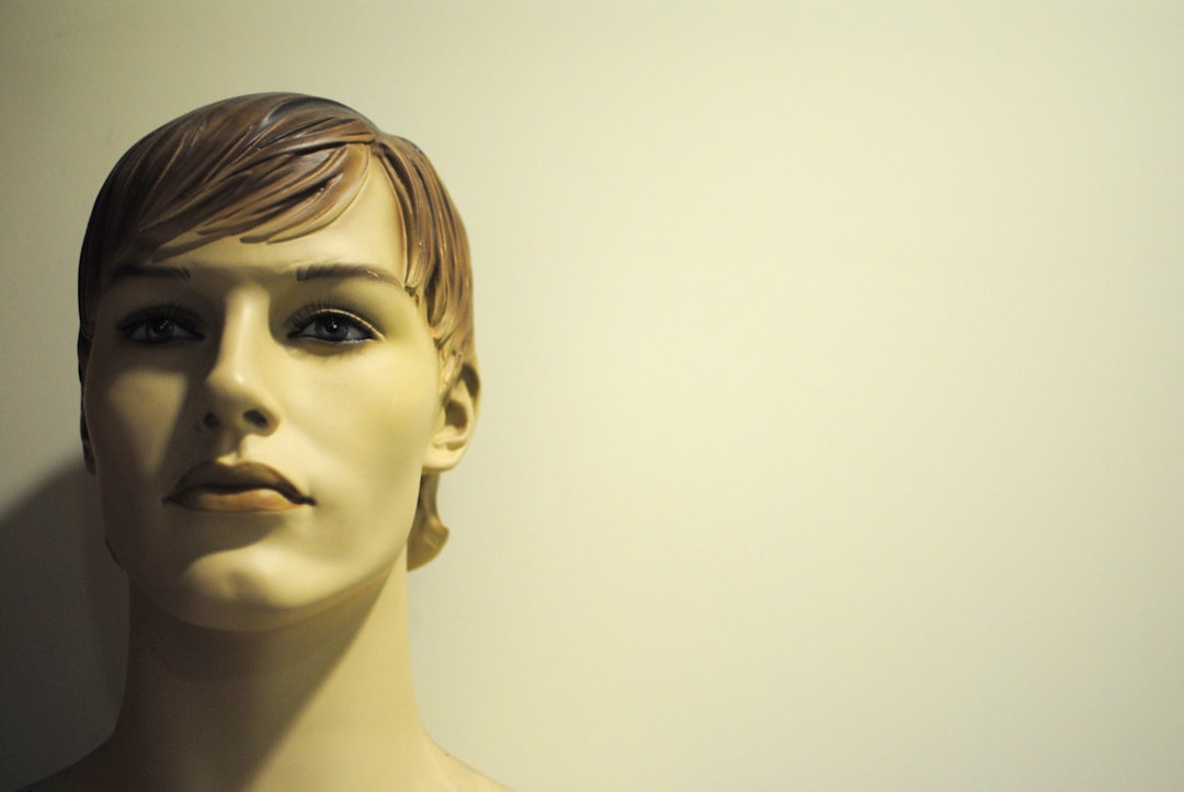 a mannequin head is shown against a white wall