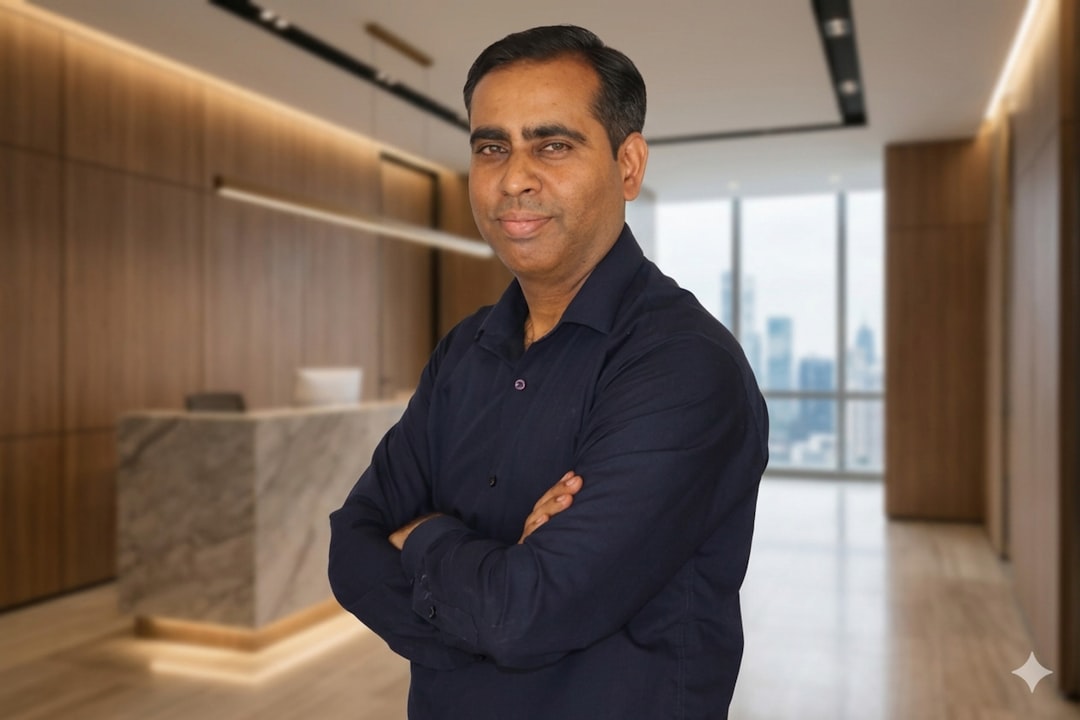 Man in a dark blue shirt with arms crossed.