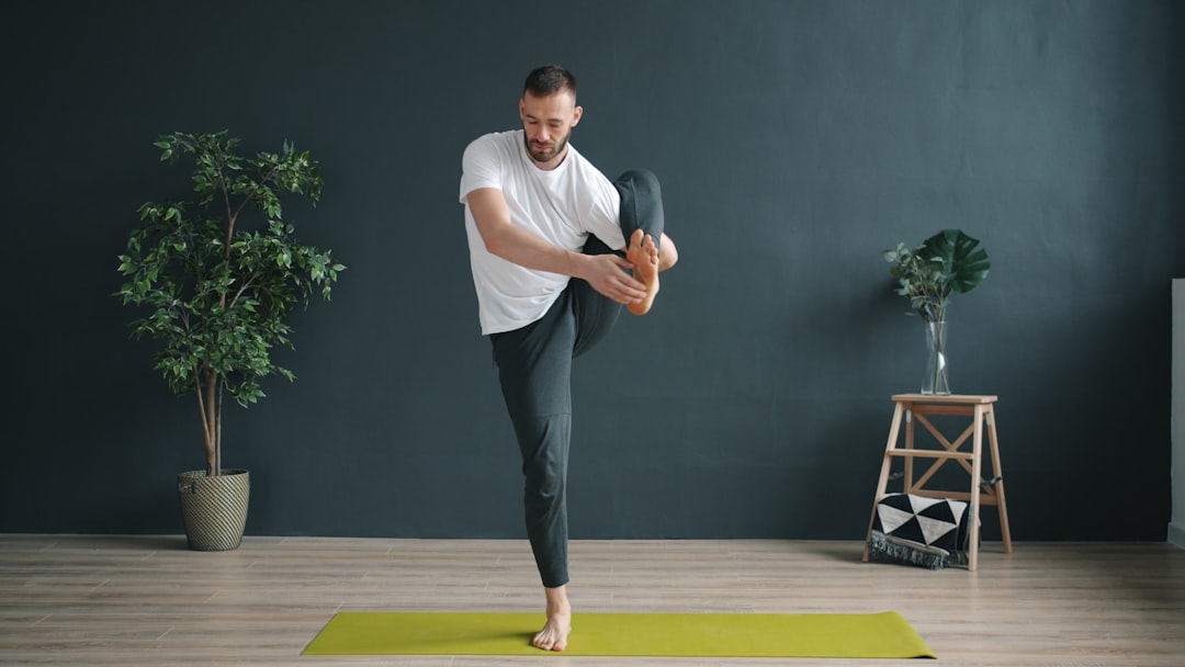 Man balancing in a yoga pose on a mat.